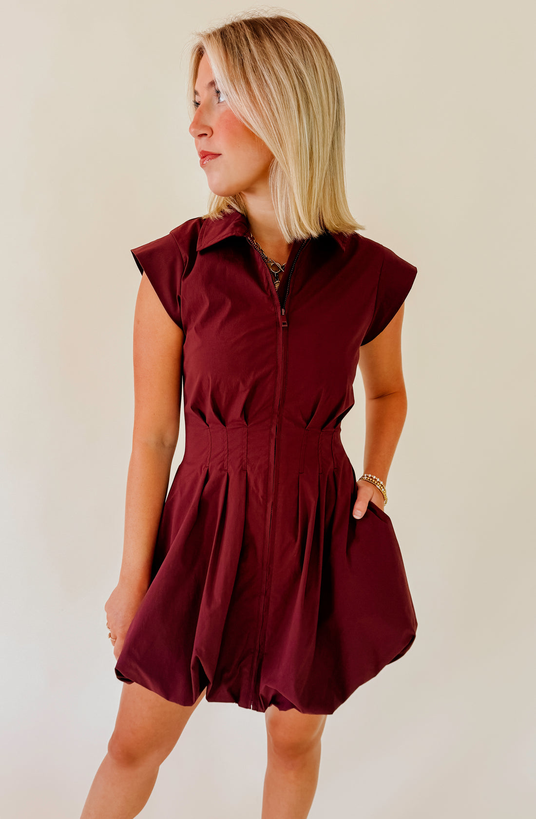 Woman wearing a brown dress against a plain background