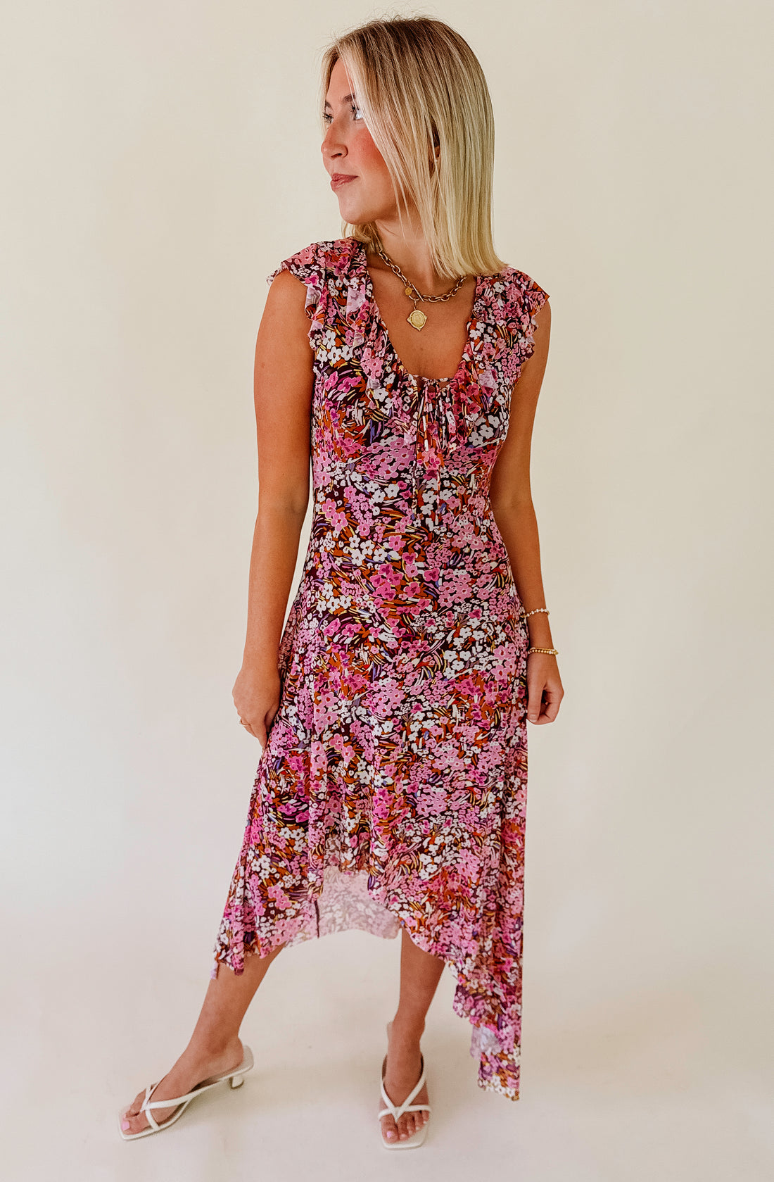 Woman wearing a floral dress against a plain background